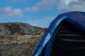 Outdoor tent with mountain in the background and blue sky with clouds