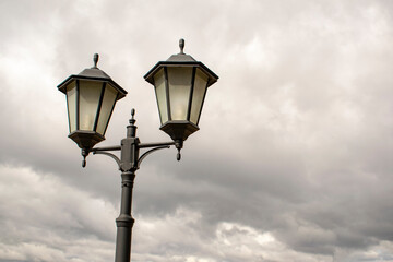 Fototapeta na wymiar Vintage street dual lights on a cloudy sky background.