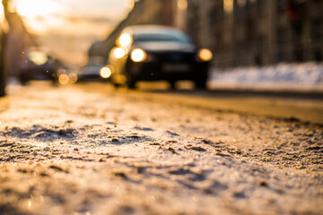 Bright winter sun in a big city, on the snowy street going car. View from the road level