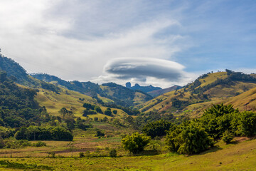 valley landscape in the mantiquira mountain with side view of Pedra do Bau and clouds