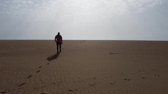 AERIAL VIEW Man walking through the dunes with ocean views