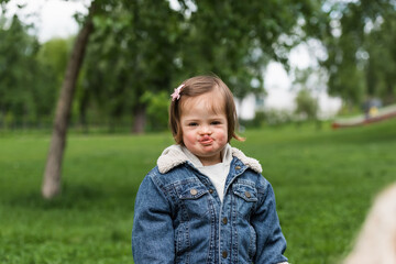 girl with down syndrome sticking out tongue while looking at camera