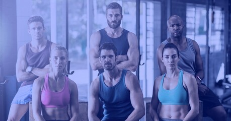Composition of group of fit people at gym over light blur