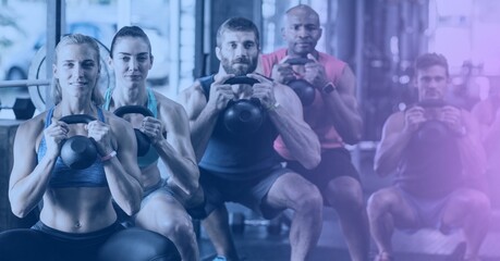 Composition of group of fit people exercising with dumbbells over light blur