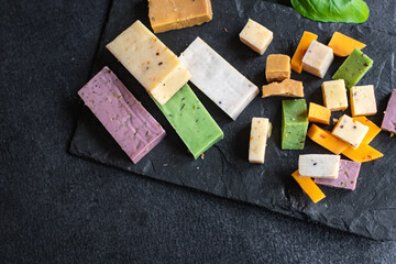 cheese different assortment variation aged cheeses basil, lavender, fenugreek, chili, baked milk, turmeric, carrot on the table healthy food meal snack copy space food background rustic top view