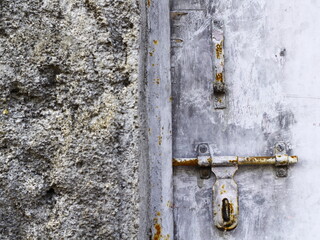 Ruined wall and old door rusty door latch