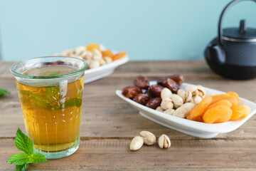 Dried fruit tray with tea glass on wooden background. Copy space.