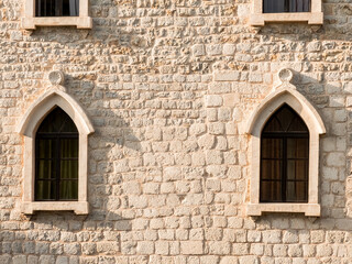 Detail of the facade of a building with two lancet windows. Mediterranean medieval architecture.