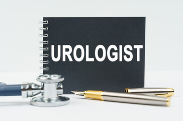 On a white background lies a stethoscope, a pen and a black notebook with the inscription - UROLOGIST