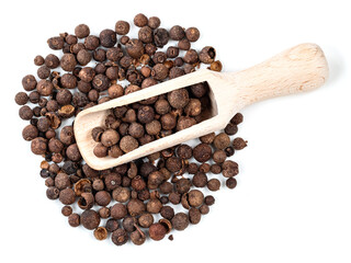 top view of wooden scoop on pile of allspice