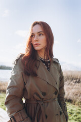 Red hair girl with freckled face outdoors near the lake. Natural beauty, eco lifestyle, nature...