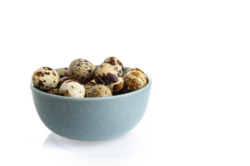 A blue bowl with quail eggs on a white background. Free space for text.