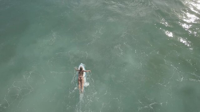 Vue a&eacute;rienne de bas en haut, nature tropicale, femme. qui nage avec sa planche de surf. Oc&eacute;an sud du Panama