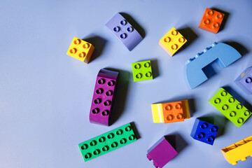 Colorful plastic construction blocks on pink background ,copy space for text. Flat lay. Top view.children's construction set.Kid building with geometric shapes. Learning and education concept.