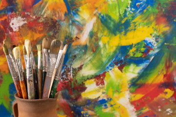 Paint brush in clay jug and oil painting  background texture. Paintbrush painting and art still life