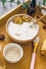 Homemade cosmetic cream with banana from natural ingredients. Banana face mask at home for wellness skin and body care. Diy natural cosmetics concept background