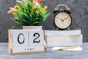 June 2nd. June 2 wooden cube calendar with blur objects on background.