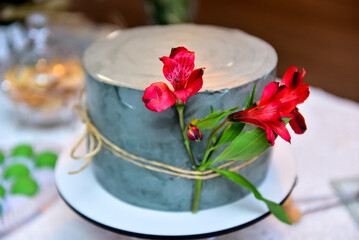 Table setting with red flowers and cake with rustic decor, birthday party