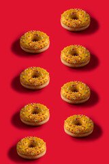 Yellow glassed  donuts  with  shadow  on red background. Pattern
