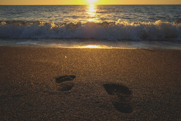 footprints at the beach during sunset, orme di piedi in spiaggia durante il tramonto