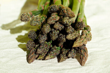 close green asparagus lies on a light beige background front view. raw vegetable. veganism