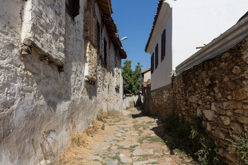 Fototapeta na wymiar View of narrow street, old historical houses in famous, touristic Aegean mountain village called 
