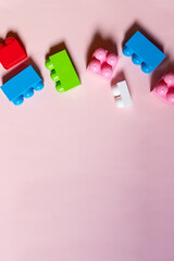 Multicolored plastic kids constructor on blue background. Colored children's bricks for construction. Flat lay top view copy space. Plastic building blocks background. Developing toys, game