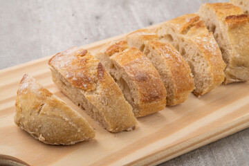 Traditional homemade french baguette bread slices over wooden board
