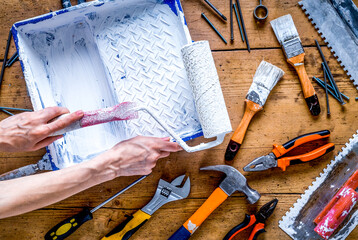 building decoration instruments with paint, roller, palette-knife on wooden background top view