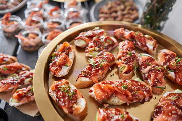 Delicious bruschetta with salmon and canape shrimp on table. Tasty buffet table. Summer party. Catering concept