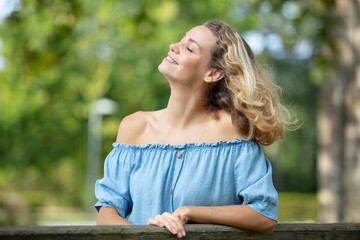woman outdoors enjoys the breeze on her face