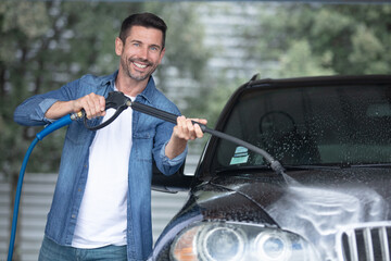 man car washing under the water pressure