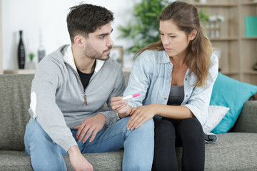 couple holds test stick with frustration