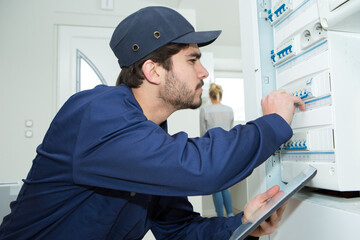 electrical technician mending the panel switch