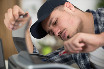 upset man fixing a printer