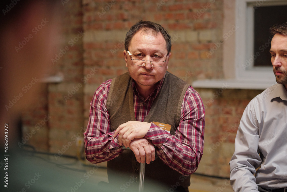 Wall mural aged man in eyeglasses and casualwear describing his problem at psychological session