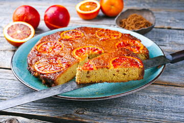 Modern style traditional Italian blood orange ricotta pie with fruits and almonds served as close-up on a Nordic design plate with copy space