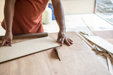 Carpenter working with Industrial tool in wood factory, circular blade with a wood board