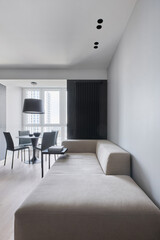 Minimalist stylish sofa in the dining area with leather chairs in the studio in monochrome colors