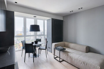 Minimalist stylish sofa in the dining area with leather chairs in the studio in monochrome colors