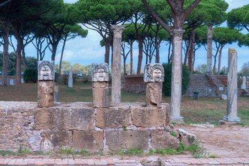 stone theatrical masks on ancient columns in the ancient Italian city of Ostia Antica
