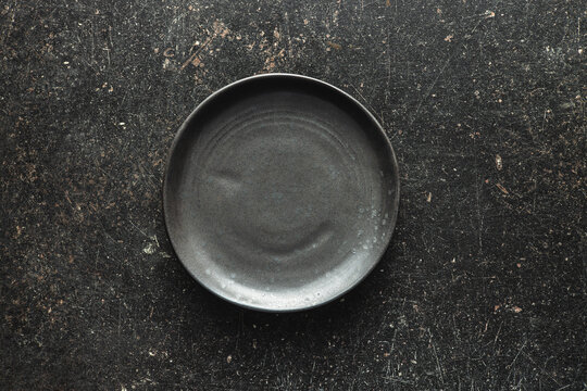 Empty vintage plate on black table.