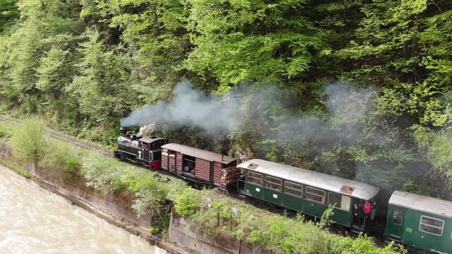 Old steam train from North Romania passing near water valley