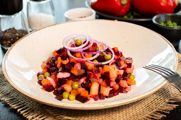 Vinaigrette. Traditional russian beetroot salad with boiled vegetables, pickled cucumbers, sour cabbage, olive oil and green canned peas. Vegetarian healthy dinner. Served in restaraunt.