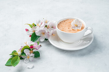 Fresh morning coffee and flowers on a light background. Side view, copy space.