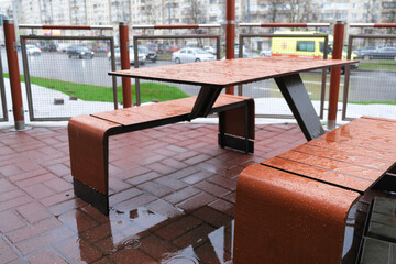 Raindrops on the tables and chairs of an empty street cafe