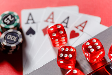 Red playing dice, gambling chips and cards with aces close-up