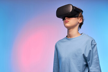 Confident Teenage Boy In VR Glasses Looking Away Seriously, Imagine Something Fantastic, Dressed...