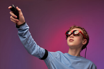 Young boy getting experience using VR-headset glasses of virtual reality in studio much...