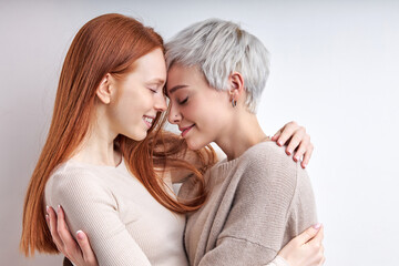 Two caucasian cool generation z women lgbtq lesbian couple dating in love hugging enjoying intimate tender sensual moment together feeling love isolated on white background. Close up view - obrazy, fototapety, plakaty